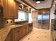 Gourmet kitchen with wooden cabinets, granite countertops, stainless steel appliances, and travertine tile floors at 35 Watergate Dr # 1103, Sarasota, FL 34236