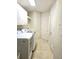 Functional laundry room featuring ample cabinetry, tile flooring, and a washer and dryer at 35 Watergate Dr # 1103, Sarasota, FL 34236