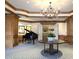 Community lobby featuring a piano, coffered ceilings, and elegant decor, creating a welcoming and refined atmosphere at 35 Watergate Dr # 1103, Sarasota, FL 34236