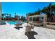 An inviting poolside patio features comfortable seating under a pergola with views of the pool and buildings at 35 Watergate Dr # 1103, Sarasota, FL 34236