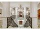 Grand staircase with ornate railings and a stunning chandelier creating a dramatic entrance at 35 Watergate Dr # 1103, Sarasota, FL 34236