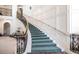 Elegant curving staircase featuring wrought iron railings, carpeted steps and paneled walls, adding a touch of sophistication at 35 Watergate Dr # 1103, Sarasota, FL 34236