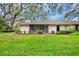 Rear exterior showcasing a well-manicured lawn and screened-in lanai at 3561 Wilkinson Woods Dr # 35, Sarasota, FL 34231