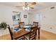 Dining room with a wooden table set for four, ceiling fan, and access to a bright kitchen and hallway at 3664 Lake Bayshore Dr # K323, Bradenton, FL 34205