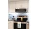 Close up of stainless steel oven and microwave with designer tile backsplash and granite countertops at 3664 Lake Bayshore Dr # K323, Bradenton, FL 34205