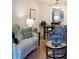 Cozy living room with a white sofa, patterned chair, and a glass coffee table, adjacent to a dining area at 3664 Lake Bayshore Dr # K323, Bradenton, FL 34205