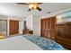 Comfortable bedroom with wood wardrobes, a ceiling fan, and a view into the bathroom at 3809 21St W Ave, Bradenton, FL 34205