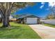 Charming home showcasing manicured lawn and stone accents with a two-car garage, and mature trees at 3809 21St W Ave, Bradenton, FL 34205