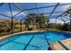Sparkling screened pool with blue tile and brick accents, perfect for enjoying sunny days and outdoor relaxation at 3809 21St W Ave, Bradenton, FL 34205