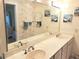 Bathroom with a double sink vanity, a large mirror, and decorative wallpaper at 3818 Sun Eagle Ln, Bradenton, FL 34210