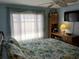 Inviting bedroom with a decorative window, ceiling fan, and a comfortable bed with floral bedding at 3818 Sun Eagle Ln, Bradenton, FL 34210