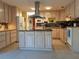 Kitchen with island, black granite countertops, light colored cabinetry, a microwave, and a refrigerator at 3818 Sun Eagle Ln, Bradenton, FL 34210