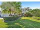 Well-manicured home exterior featuring lush landscaping, mature palms, a vibrant lawn, and trimmed shrubbery at 3880 Wilshire Cir # 28, Sarasota, FL 34238