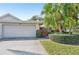 Charming home exterior featuring a well-manicured lawn, mature palm trees, and a two-car garage at 3880 Wilshire Cir # 28, Sarasota, FL 34238