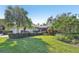 Wide shot of a landscaped property featuring a well-maintained lawn, trimmed shrubbery, and mature palm trees at 3880 Wilshire Cir # 28, Sarasota, FL 34238