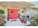 Inviting front entrance with a vibrant red door, decorative wreath and cozy seating area at 3880 Wilshire Cir # 28, Sarasota, FL 34238