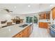 Kitchen featuring a large island, wood cabinets, stainless appliances and an adjacent dining area and fireplace at 3880 Wilshire Cir # 28, Sarasota, FL 34238