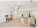 Airy living area with hardwood floors, a stylish chair, a ceiling fan, and access to other rooms at 3880 Wilshire Cir # 28, Sarasota, FL 34238