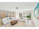 Bright living room with white sofas, light wood floors, a textured coffee table, and sliding glass doors at 3880 Wilshire Cir # 28, Sarasota, FL 34238
