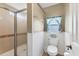 Bright bathroom with a tiled shower, toilet, and window with decorative curtains for added charm at 4304 14Th E St, Ellenton, FL 34222