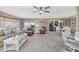 Bright living room with neutral tones, ceiling fan, and sliding glass doors to an enclosed porch area at 4304 14Th E St, Ellenton, FL 34222