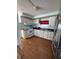 Cozy kitchen featuring white appliances, cabinets, wood floors, and a stainless steel refrigerator at 4527 13Th E St, Ellenton, FL 34222