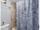 Shower with seashells patterned curtain, tiled wall, and a chrome shower head at 4532 La Jolla Dr, Bradenton, FL 34210