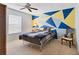 Bedroom with a geometric painted accent wall, ceiling fan, and a window with blinds at 4532 La Jolla Dr, Bradenton, FL 34210