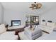 Comfortable living room features hardwood floors, a television and sliding doors to a screened-in patio at 4532 La Jolla Dr, Bradenton, FL 34210
