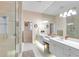 Bathroom with double sinks, large mirror, tiled floors, and a shower with glass door at 4620 Blue Marlin Dr, Bradenton, FL 34208