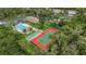 Community aerial featuring pool, shuffleboard, tennis court, and lush greenery for outdoor recreation at 5019 Village Gardens Dr # 31, Sarasota, FL 34234