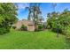 Lush backyard with well-maintained lawn, mature trees, and a view of the rear facade with a tranquil outdoor space at 5019 Village Gardens Dr # 31, Sarasota, FL 34234