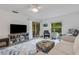 Bright living room featuring modern ceiling fan, glass sliding doors, neutral colors, and decorative rug at 5019 Village Gardens Dr # 31, Sarasota, FL 34234