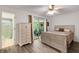 Bedroom featuring light wood floors, ceiling fan, sliders to outside, and ensuite bathroom at 5019 Village Gardens Dr # 31, Sarasota, FL 34234