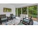 Bright sunroom featuring comfortable wicker seating, sliding glass doors and a tranquil view of the surrounding greenery at 5019 Village Gardens Dr # 31, Sarasota, FL 34234