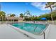 Community pool with blue accents, surrounded by lush greenery and seating area at 5019 Village Gardens Dr # 31, Sarasota, FL 34234