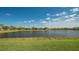 Scenic backyard overlooking a tranquil lake, framed by lush green grass and homes along the water's edge at 5361 Sundew Dr, Sarasota, FL 34238