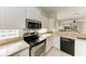 Modern kitchen with stainless steel appliances and tile flooring, with a view to the living room at 6970 Mystic Ln, Sarasota, FL 34243