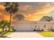 Charming single-story home with a barrel tile roof, lush landscaping, and a paver driveway leading to an attached garage at 7431 Dickens Dr, Sarasota, FL 34231