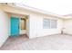 Charming home entrance with a vibrant blue door, brick pathway, and ample natural light at 7431 Dickens Dr, Sarasota, FL 34231