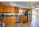 Eat-in kitchen features stainless steel appliances, ample wood cabinetry, and tile backsplash with a view to the dining area at 7431 Dickens Dr, Sarasota, FL 34231