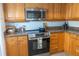 Close up of the kitchen features stainless steel appliances, ample wood cabinetry, and tile backsplash at 7431 Dickens Dr, Sarasota, FL 34231