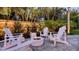 Relaxing backyard featuring a modern fire pit, Adirondack chairs, and lush tropical landscaping around the perimeter at 7715 Westmoreland Dr, Sarasota, FL 34243
