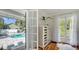 Spacious bedroom with dresser, hardwood floors and view of an outdoor pool area, accessible through French doors at 7715 Westmoreland Dr, Sarasota, FL 34243
