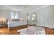 Comfortable bedroom with hardwood floors, white walls, sheer curtains, and a view of a mirror and possible bathroom at 7715 Westmoreland Dr, Sarasota, FL 34243