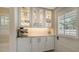 A bright butler's pantry featuring custom cabinetry, marble countertops, and stylish design accents at 7715 Westmoreland Dr, Sarasota, FL 34243