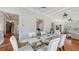 Dining room with a glass table, seating for six, and views of the staircase and living room at 7715 Westmoreland Dr, Sarasota, FL 34243