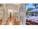 Elegant hallway features hardwood floors, french doors, and views of the backyard pool and patio at 7715 Westmoreland Dr, Sarasota, FL 34243
