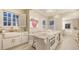 Bright kitchen with a farmhouse sink, marble countertops, island with microwave, and elegant chandeliers at 7715 Westmoreland Dr, Sarasota, FL 34243