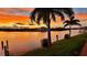 Picturesque waterfront property featuring a serene canal view and vibrant sunset over the lush landscape at 8106 Arlewood Cir, Port Charlotte, FL 33981